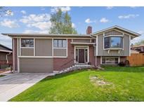 Charming exterior featuring a well-maintained lawn, brick accents, and a cozy entrance at 12752 W Asbury Pl, Lakewood, CO 80228