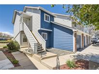 Charming multi-level home featuring blue and white siding, inviting front entrances with stairs, and low-maintenance landscaping at 1351 S Cathay Ct # 102, Aurora, CO 80017