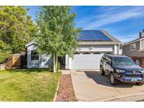 Inviting home exterior featuring solar panels, a well-kept lawn, and an attached two-car garage at 9805 Garrison Ct, Broomfield, CO 80021