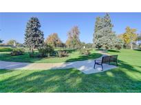 Beautiful community park with walking path and benches surrounded by lush greenery and mature trees at 1050 N Lafayette St # 408, Denver, CO 80218