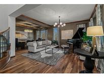 Elegant living room boasts hardwood floors, a grand piano, and sophisticated decor, creating a luxurious ambiance at 25312 E Glasgow Pl, Aurora, CO 80016