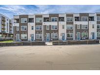 Modern townhome complex with brick facade, white accents, and individual entryways at 370 Geneva St, Aurora, CO 80010
