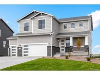 Charming two-story home with gray siding, stone accents, three-car garage, and a well-manicured front lawn at 42964 Colonial Trl, Elizabeth, CO 80107