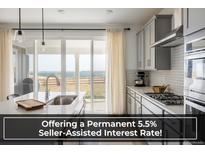 Modern kitchen featuring a large island, stainless steel appliances, and sliding glass doors with scenic views at 16568 W 92Nd Pl, Arvada, CO 80007