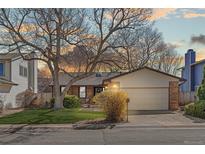 Charming single-story home with brick accents, a two-car garage and a lush front yard at 2158 S Elkhart St, Aurora, CO 80014