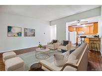 Cozy living room with wood floors, and furniture leading into an updated kitchen at 9385 E Center Ave # 1D, Denver, CO 80247