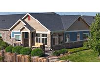 Charming home featuring stone accents, tan siding, and a cozy front porch with a seating area at 12604 Madison Way, Thornton, CO 80241