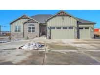 Green two-story house with stone accents and a three-car garage at 7301 E 82Nd Pl, Commerce City, CO 80022