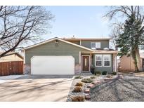Charming two-story home featuring a well-manicured front yard and a large two car garage at 13812 W 66Th Dr, Arvada, CO 80004