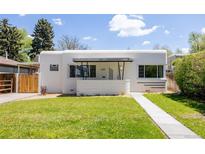 Unique home with flat roof, stucco siding, minimalist landscaping, and art deco design elements at 1010 N Jasmine St, Denver, CO 80220