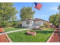 Charming single-story home with a well-manicured lawn and a welcoming front porch featuring an American flag at 3790 W 54Th Ave, Denver, CO 80221