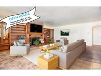 Cozy living room featuring a brick fireplace, built-in shelves, and stylish, neutral furniture at 3790 W 54Th Ave, Denver, CO 80221