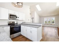 Modern kitchen with stainless steel appliances, granite countertops, and a breakfast bar at 7722 S Steele St, Centennial, CO 80122