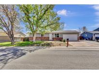 Charming single-story home featuring a brick facade and mature landscaping at 6434 S Dudley Way, Littleton, CO 80123