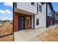 New townhome featuring a brick facade, gray trim, and inviting covered front entrance at 1335 N Alton St, Aurora, CO 80010