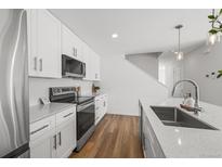 Modern kitchen with white cabinets, stainless steel appliances, and quartz countertops at 1335 N Alton St, Aurora, CO 80010