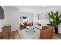 Bright living room with white walls, contemporary furniture, wood floors, and a neutral rug at 1335 N Alton St, Aurora, CO 80010