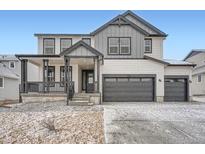 Charming two-story home with a covered front porch and an attached two-car garage at 39420 Congress Ln, Elizabeth, CO 80107