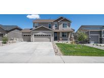 Charming two-story home with a three car garage, well-manicured lawn, and neutral-toned exterior at 6065 Clover Ridge Cir, Castle Rock, CO 80104