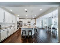 A gourmet kitchen offers stainless appliances, granite countertops and a large island with seating at 6065 Clover Ridge Cir, Castle Rock, CO 80104