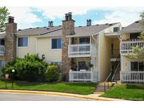 Inviting two-story condo with double balcony, stone chimney, and well-maintained lawn at 8555 Fairmount Dr # C202, Denver, CO 80247