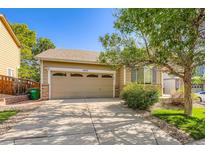Charming home featuring a two-car garage, well-maintained lawn, and mature trees in a pleasant neighborhood at 5037 Pelican St, Brighton, CO 80601