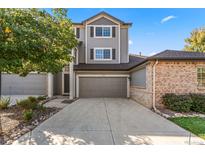 Charming two-story home with gray siding, brown shutters, and a spacious two-car garage at 1415 S Ulster St, Denver, CO 80231