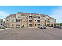 Multi-Gathering condo building showcasing brick and siding facade with individual balconies and parking area in front at 1841 S Dunkirk St # 207, Aurora, CO 80017