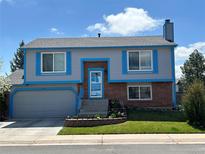 Charming two-story home features a well-maintained lawn, brick accents, and bright blue trim at 430 Chestnut Way, Broomfield, CO 80020