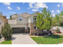Stunning two-story stucco home with stone accents, balcony, manicured lawn, and mature trees at 10832 Montvale Cir, Highlands Ranch, CO 80130
