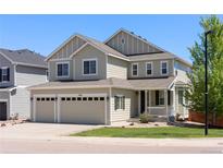 Charming two-story home with a three car garage and landscaped front yard on a sunny day at 1382 Raindrop Way, Castle Rock, CO 80109