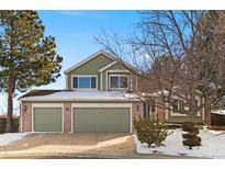 Two-story house with attached two-car garage and snow-covered yard at 9436 Wickerdale Ct, Highlands Ranch, CO 80130