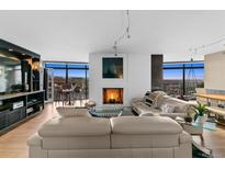 Bright living room boasts fireplace, hardwood floors, city views and modern decor at 1777 Larimer St # 2108, Denver, CO 80202