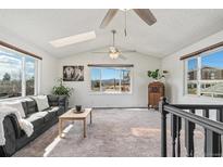 Bright living room with vaulted ceilings, lots of natural light, and mountain views at 6190 Garrison St, Arvada, CO 80004