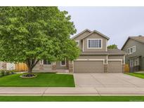 Charming two-story home featuring a three-car garage, well-manicured lawn, and inviting curb appeal at 334 Octillo St, Brighton, CO 80601