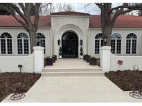 Stunning exterior with an arched doorway, tile roof, and decorative planters leading to the entrance at 4 Cherry Hills Farm Dr, Cherry Hills Village, CO 80113