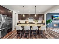 Modern kitchen featuring a large island with seating and stainless steel appliances at 7875 S Grand Baker St, Aurora, CO 80016