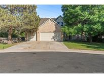 Charming home featuring a three-car garage, brick facade, and mature trees at 634 E 130Th Way, Thornton, CO 80241
