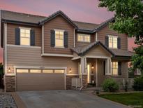 Beautiful two-story home with wood siding, stone accents, and a well-manicured lawn at 10371 Knollside Dr, Parker, CO 80134