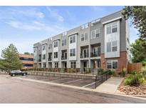 Modern townhome complex with gray siding, brick accents, and rooftop terraces, offering contemporary living at 8711 E Hampden Ave # 22, Denver, CO 80231