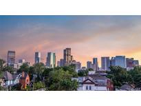 Beautiful downtown skyline view overlooking lush trees and neighborhood buildings with warm sunset in Denver, Colorado at 2721 Curtis St, Denver, CO 80205