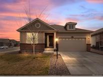 Charming single-Gathering home featuring a two-car garage and manicured front yard at sunset at 15788 Xanthia Way, Thornton, CO 80602