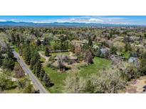 Scenic aerial view of a home nestled among mature trees with mountain views in the distance at 4480 S Franklin St, Cherry Hills Village, CO 80113