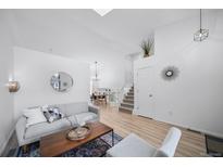 Bright living room featuring an open layout, wood floors, and staircase to the second floor at 7072 Palisade Dr, Highlands Ranch, CO 80130