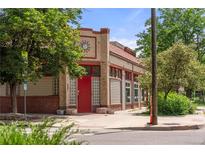 Unique building with brick accents, a red door, and charming architectural details at 2862 Champa St, Denver, CO 80205
