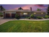 Charming single-story home with brick and stone accents, lush lawn, and a two-car garage at 90 Ammons St, Lakewood, CO 80226