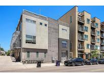 Modern townhome with mixed material facade, including stucco, wood, and metal accents, situated on a city street at 2103 W 32Nd Ave # 10, Denver, CO 80211