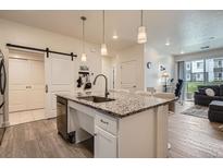 Modern kitchen features granite counters, an island with a sink, and stainless steel appliances at 16841 Askins Loop # 105, Parker, CO 80134