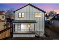 Two-story modern farmhouse with gray siding, blue door and deck at 3880 Sheridan Blvd, Denver, CO 80212