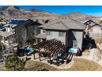 Aerial view of a backyard featuring a patio, pergola, hot tub, and beautiful mountain views at 15798 Weaver Gulch Dr, Morrison, CO 80465